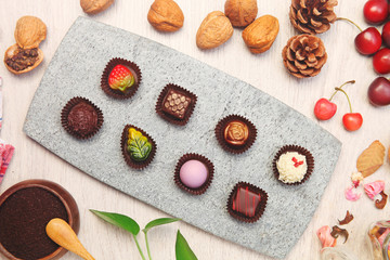 Chocolate candies of different shapes on gray slate plate 