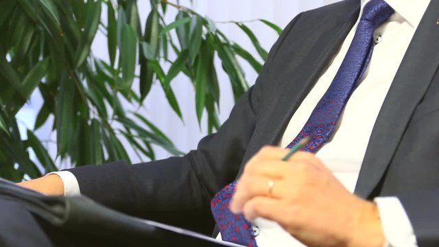 Businessman or politician giving live interview. Body language gesticulation with hands. Close up shot.
