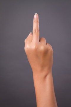 hand pointing up middle finger, concept of rude hand sign or hand gesture, studio isolated