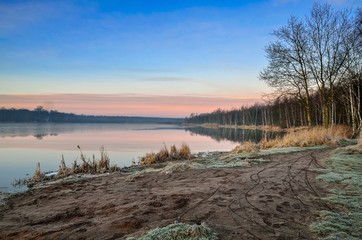 Beautiful winter landscape. Morning on the shore of the lake.