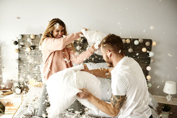 Couple having a fun while pillow fight