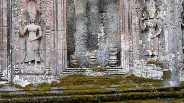 Siem Reap,Cambodia-December 23, 2017: Relief of devatas carved on sandstone in Ta Prohm in Siem Reap, Cambodia. Red paint is still recognizable.
