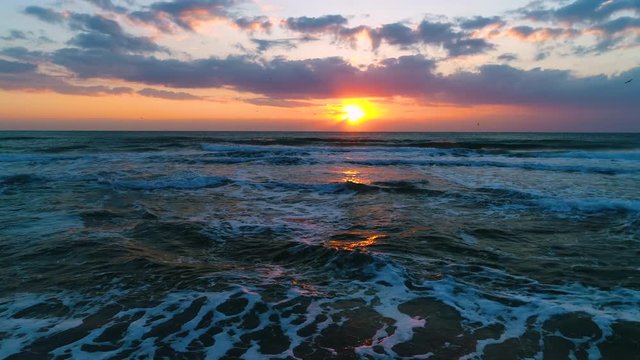Golden sunrise with dramatic cloudscape over the sea waves video