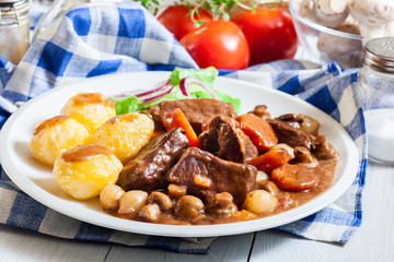 Beef Bourguignon stew served with baked potatoes