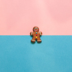 gingerbread man on pink and blue background. the concept of new and Christmas. winter holiday treats