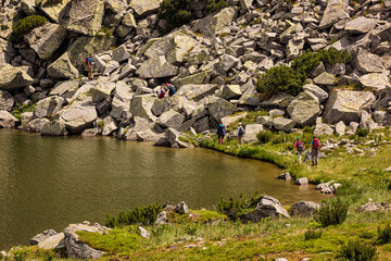Group of young hikers seen from afar starting a trekking path in the mountains of Romania
