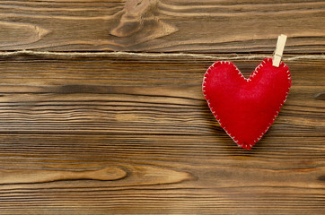 felt heart on ribbon on wooden background