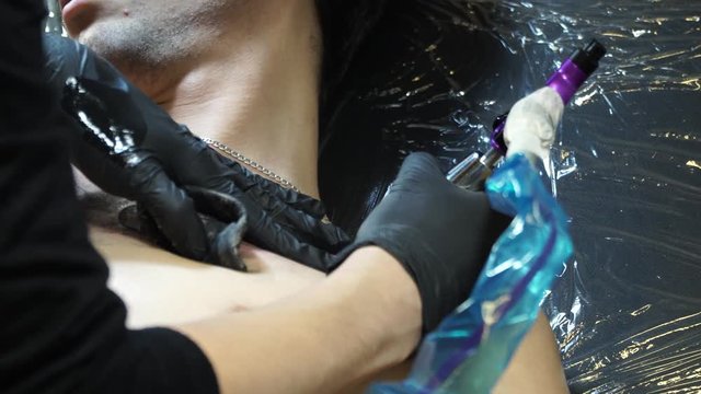 A girl tattoo artist is tattooing. Professional tattoo artist