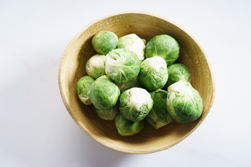 fresh brussels sprouts in wooden bowl.