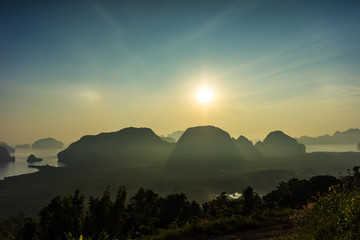 Scenic viewpoint of Phang Nga Bay from Semet Nang She mountain with silhouette island and mountain with morning sunlight.