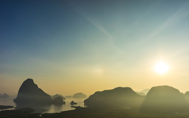 Scenic viewpoint of Phang Nga Bay from Semet Nang She mountain with silhouette island and mountain with morning sunlight.
