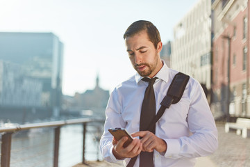 Junger Geschäftsmann nutzt Smartphone App