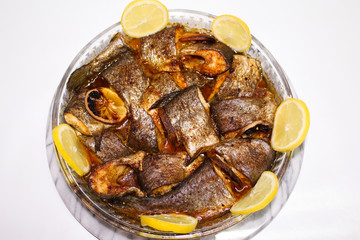 Gebratener leckerer Fisch mit Zitrone auf weiße Hintergrund