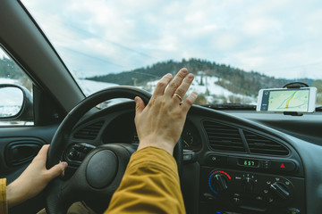 Driver's hands on a steering wheel and blurred road