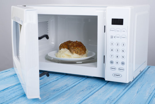 white microwave oven, on a blue wooden surface for heating food