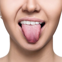 Close-up portrait of woman shows tongue grimace.