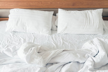 White pillow with rumpled bed