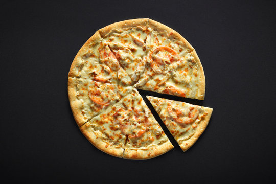 Pizza with chicken cheese and tomato on a black stone background