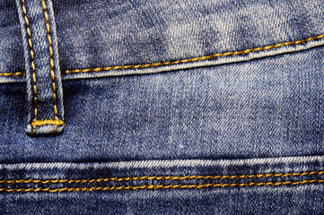 An element of denim clothing. Dedicated seams with a yellow thread. Style.
