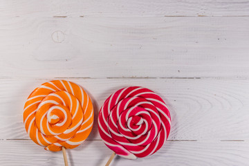 Sweet lollipops on white wooden background. Top view