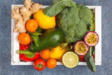 Fresh fruits and vegetables in a white wooden box. A healthy vegetarian farm food concept. Top view