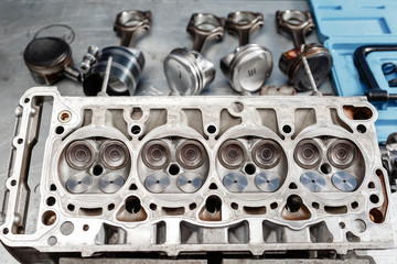 Disassemble engine block vehicle. Motor capital repair. Sixteen valve and four cylinder. Car service concept. The job of a mechanic. Old and new pistons. Top view