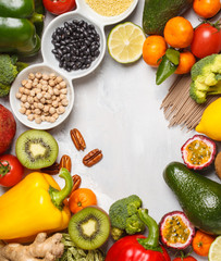 Healthy vegan food concept. Fruits vegetables background. Fresh vegetables, exotic and seasonal fruits, cereals, pasta, nuts and beans for a vegetarian diet, top view. Copy space, light background.