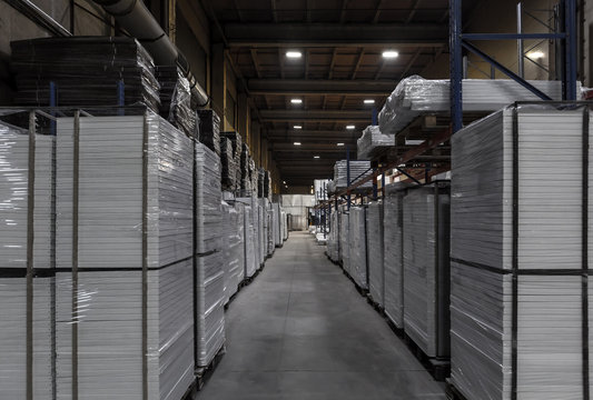 Generic warehouse industrial interior with palettes stacked on shelves. Wide angle view