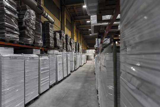 Generic warehouse industrial interior with palettes stacked on shelves. Wide angle view