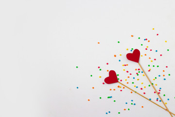 Hearts on sticks and colored decorations on a white background