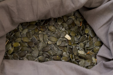 Pumpkin seeds. Organic raw peeled pumpkin seeds in a grey sack
