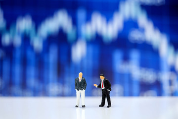 Miniature people : businessman standing with  stock market number background,Concept of financial stock market.