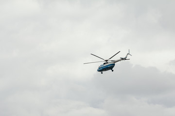 Fototapeta na wymiar Commercial passenger helicopter mi-8 with a working propeller flying against sky