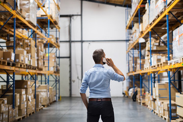 Warehouse worker or supervisor with a smartphone.