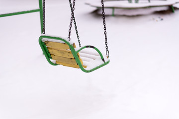 Swing covered with snow as outdoor facility