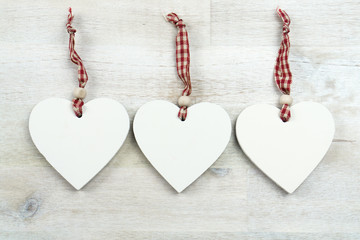 Three hearts of wood on wooden background