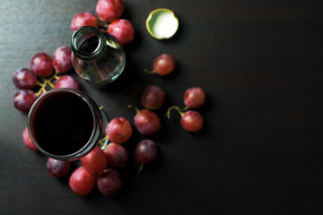 Grape juice separated in glass on a wooden table with grapes.Top view with copy space