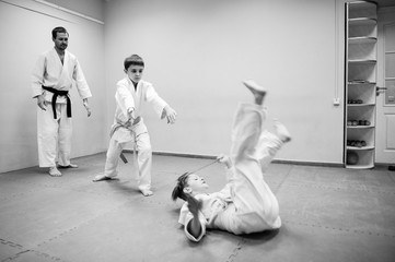 Boys in a kimono have an aikido training with a coach