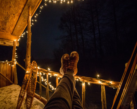 Low section of man relaxing in log cabin