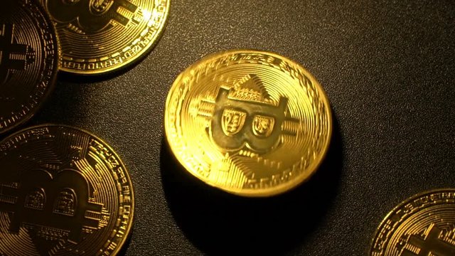 Bitcoin revolves on black background. Slow motion