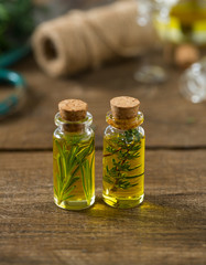 olive oil with herbs on wooden surface