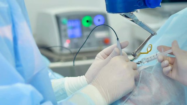 An assistant gives new medical tools to a surgeon. 