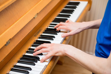 Close up of the hands of a man that's playing the piano