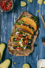 Mexican tacos with salsa and avocado on the wooden blue background, top view