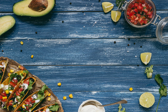 Mexican tacos with salsa and avocado on the wooden blue background, top view