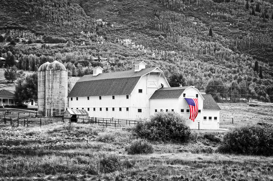 Typical vintage american barn with american flag, Park City, Utah - Black and white photography, selective color.