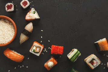 Sushi and rolls background, closeup on black, top view.