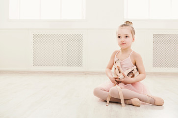 Portrait of little ballerina on floor, copy space © Prostock-studio