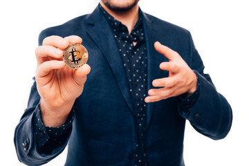 Fototapeta premium Close up of hands of handsome man pointed gold bitcoin on camera isolated on white background