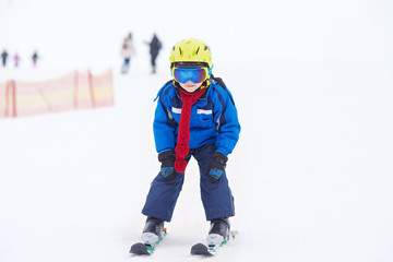 Fototapeta na wymiar Young child, skiing on snow slope in ski resort in Austria